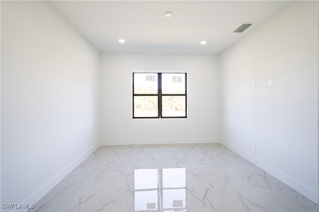 spare room featuring recessed lighting, marble finish floor, and baseboards