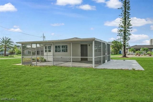 back of house featuring a patio area, a sunroom, and a yard