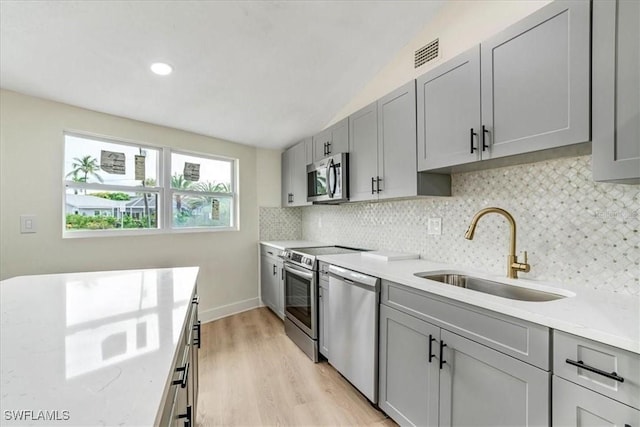 kitchen featuring gray cabinetry, visible vents, stainless steel appliances, and a sink