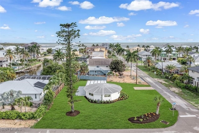 view of home's community featuring a lawn, a residential view, and a water view