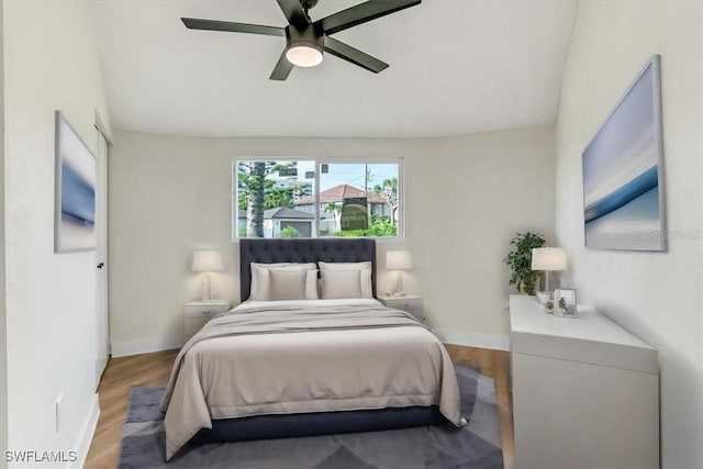 bedroom with ceiling fan, baseboards, and wood finished floors
