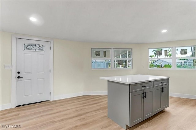 kitchen featuring light wood-type flooring, light countertops, baseboards, and gray cabinets