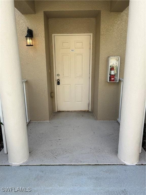 view of exterior entry with stucco siding