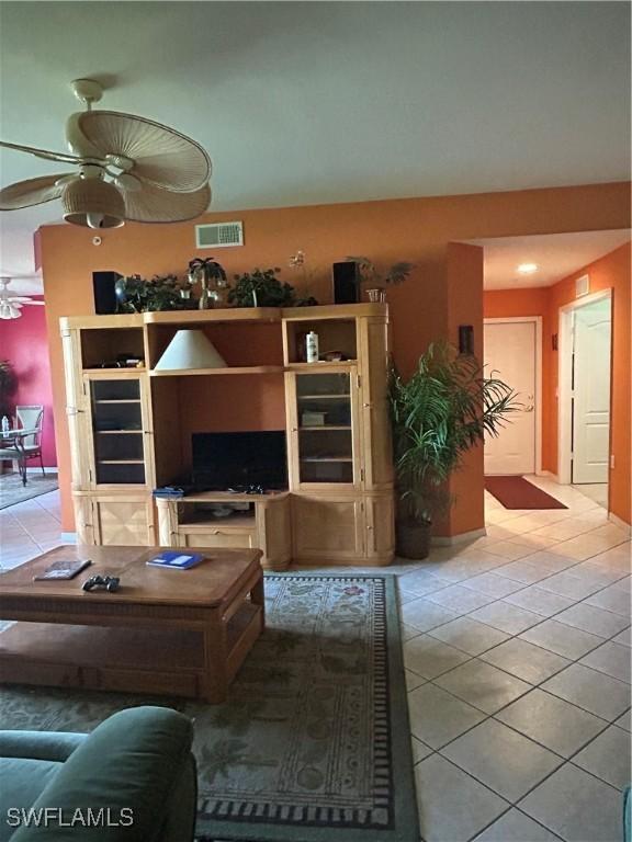 tiled living room featuring visible vents and a ceiling fan