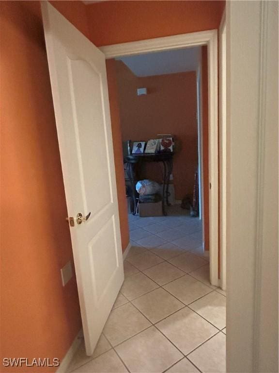 hallway with light tile patterned floors and baseboards