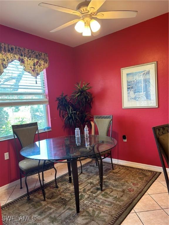 dining area with light tile patterned floors, baseboards, and ceiling fan