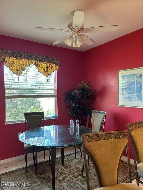 dining space with light tile patterned flooring and a ceiling fan