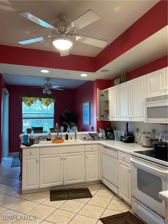 kitchen featuring light countertops, a peninsula, white appliances, white cabinetry, and a ceiling fan