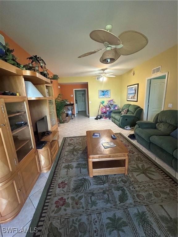 living room featuring tile patterned floors, visible vents, and a ceiling fan