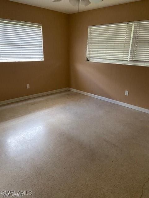 spare room featuring baseboards and ceiling fan