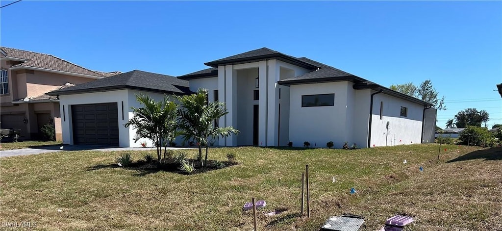 view of front of property with a front lawn, a garage, and stucco siding