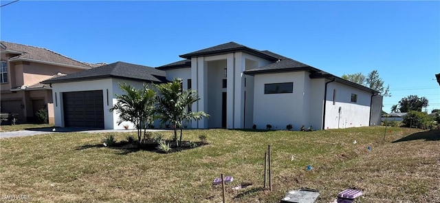 view of front of property with a front lawn, a garage, and stucco siding