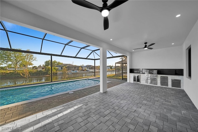 310 SW 31st Ter, Cape Coral, FL 33914 - outdoor pool featuring glass enclosure, exterior kitchen, a ceiling fan, and a patio