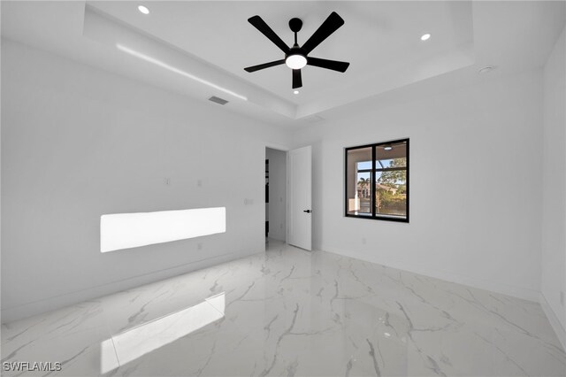 310 SW 31st Ter, Cape Coral, FL 33914 - empty room with visible vents, baseboards, a tray ceiling, recessed lighting, and marble finish floor