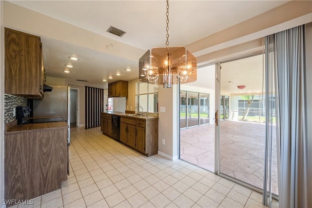 kitchen featuring baseboards, visible vents, a sink, decorative backsplash, and black dishwasher