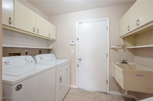 laundry room with separate washer and dryer, cabinet space, baseboards, and a sink