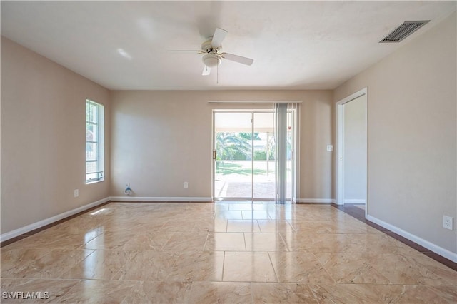 unfurnished room featuring visible vents, plenty of natural light, a ceiling fan, and baseboards