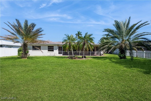 view of yard with a sunroom and fence