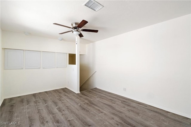 spare room featuring visible vents, baseboards, ceiling fan, and wood finished floors