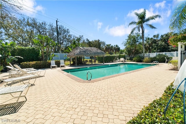 pool featuring a gazebo, a patio, and fence