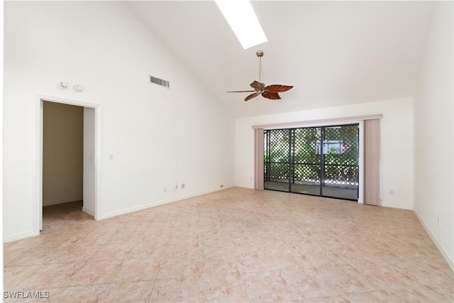 spare room featuring a ceiling fan, baseboards, visible vents, high vaulted ceiling, and a skylight