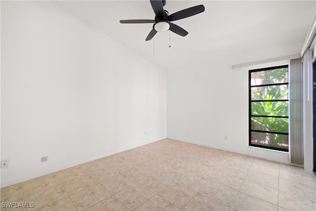 empty room featuring baseboards, lofted ceiling, and a ceiling fan