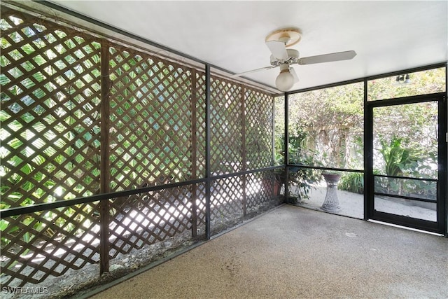 unfurnished sunroom featuring ceiling fan