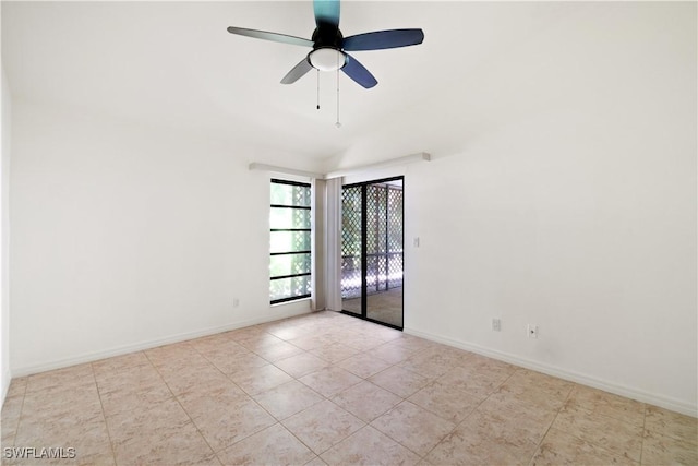 empty room featuring tile patterned floors, a ceiling fan, and baseboards