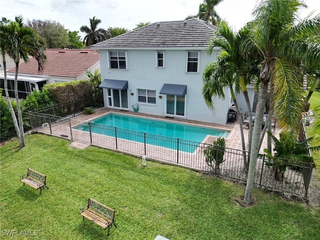 view of swimming pool featuring a patio area, a lawn, a fenced in pool, and fence