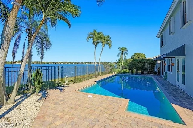 view of pool featuring a fenced in pool, a fenced backyard, french doors, a water view, and a patio area