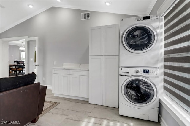 washroom with visible vents, stacked washer and clothes dryer, marble finish floor, and ornamental molding