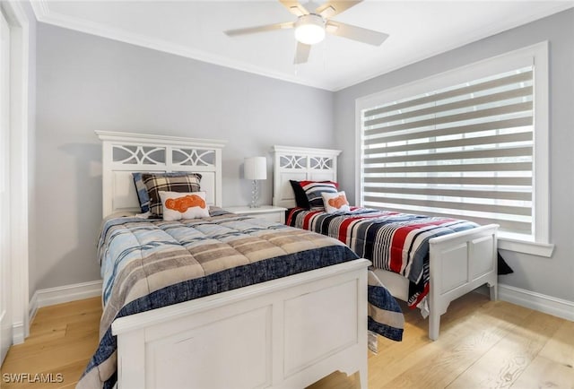 bedroom featuring light wood-style flooring, ceiling fan, baseboards, and ornamental molding