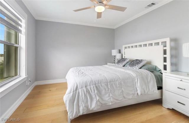 bedroom featuring visible vents, ornamental molding, a ceiling fan, light wood finished floors, and baseboards