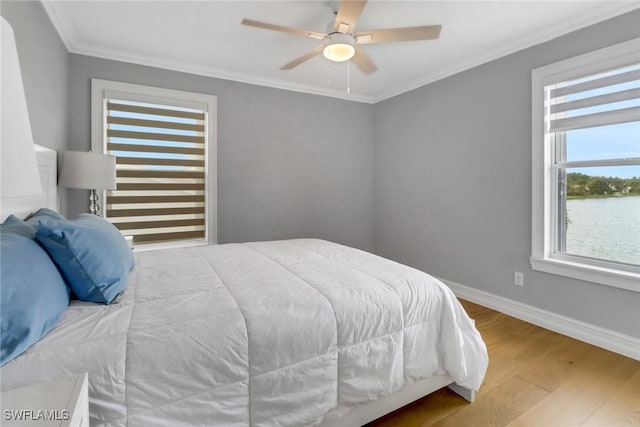 bedroom featuring ornamental molding, ceiling fan, baseboards, and wood finished floors