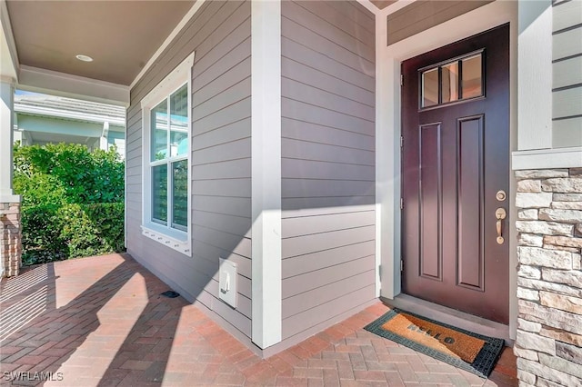 property entrance with stone siding and covered porch