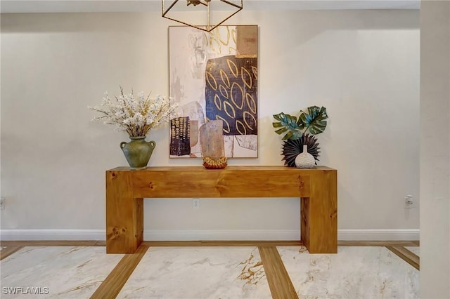 details with an inviting chandelier, wood finished floors, and baseboards