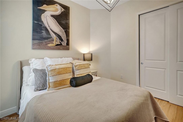 bedroom featuring a closet, baseboards, and wood finished floors