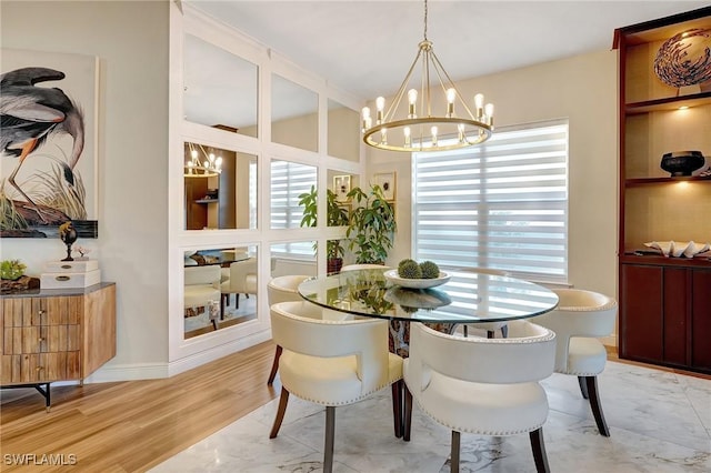 dining space featuring light wood-style flooring, a wealth of natural light, and a chandelier