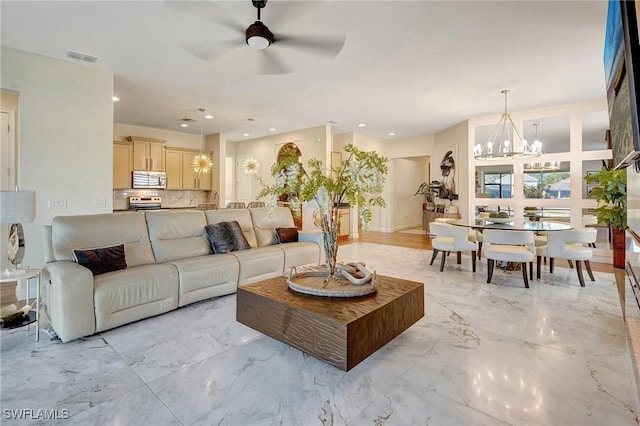 living room featuring recessed lighting, marble finish floor, ceiling fan with notable chandelier, and visible vents