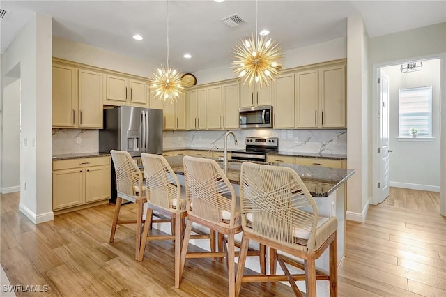 kitchen featuring visible vents, cream cabinets, appliances with stainless steel finishes, and a chandelier