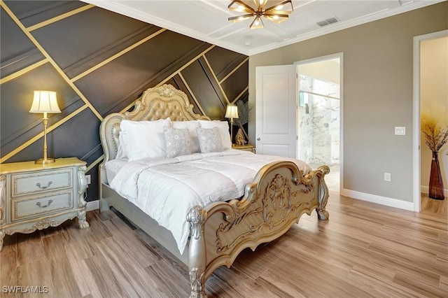 bedroom featuring baseboards, wood finished floors, visible vents, and ornamental molding