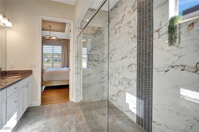 ensuite bathroom with a marble finish shower, vanity, and ensuite bathroom