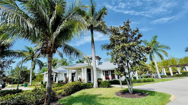 view of front of house with metal roof and a front yard