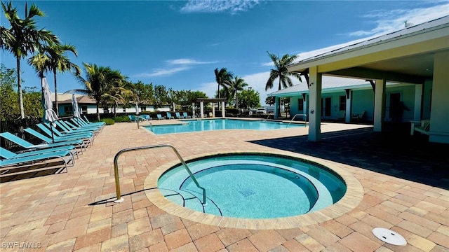 pool featuring a hot tub and a patio