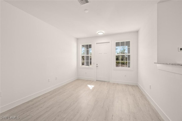 empty room with visible vents, baseboards, and light wood-style flooring