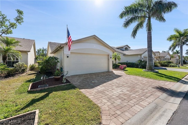 view of front of house featuring decorative driveway, a front yard, an attached garage, and stucco siding