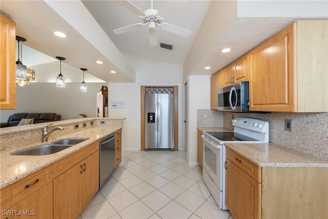 kitchen with a sink, light stone counters, stainless steel appliances, decorative backsplash, and lofted ceiling