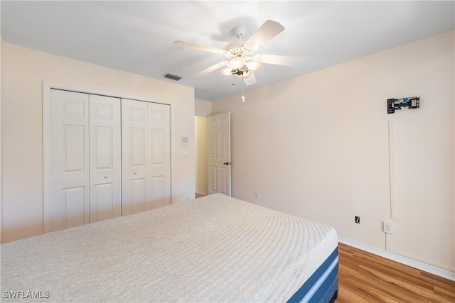 bedroom with light wood-style flooring, visible vents, a closet, and ceiling fan