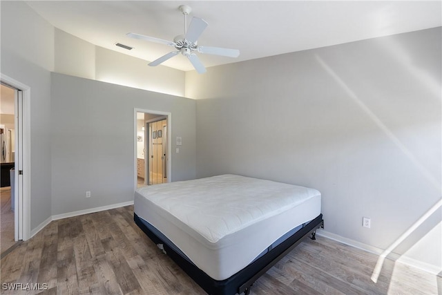 bedroom featuring visible vents, wood finished floors, connected bathroom, baseboards, and ceiling fan