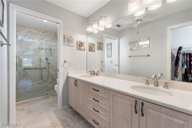 bathroom featuring a shower stall, toilet, ceiling fan, and a sink